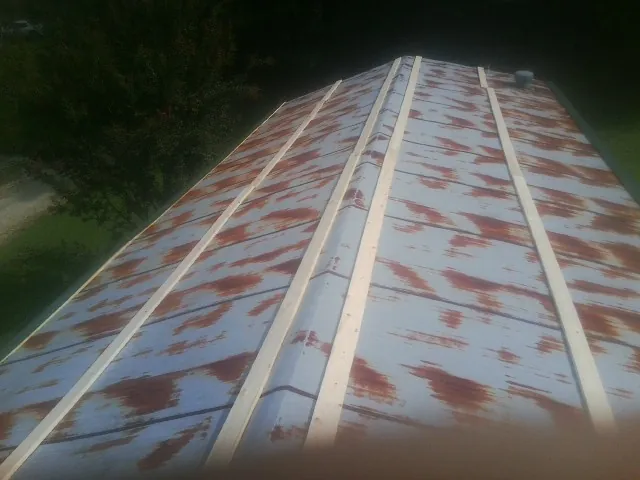 Rusted metal roof panels with new wood purlins before replacement — Storm Damage Roof Repair in Saraland by Roofing Brothers