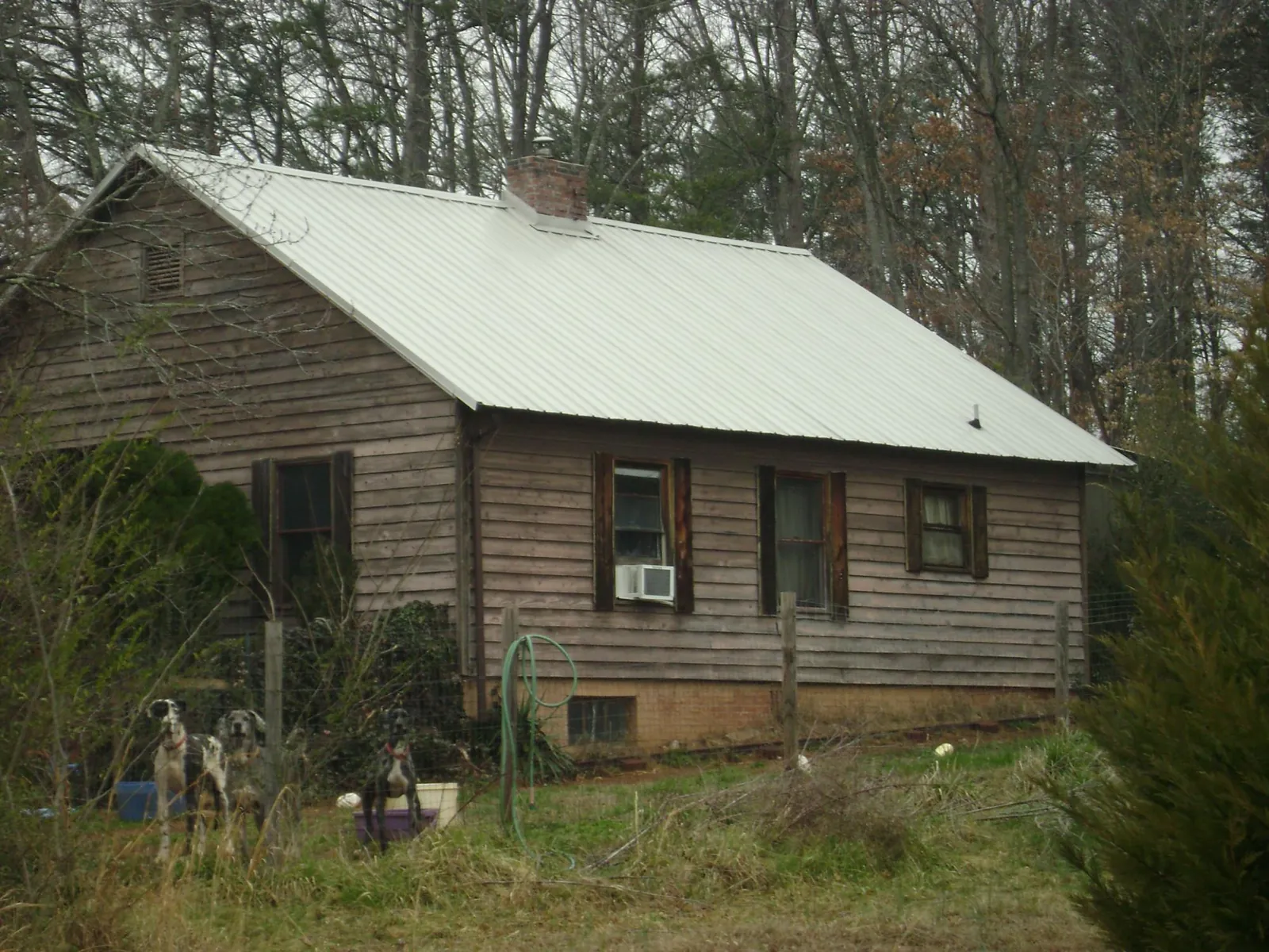 White metal roof on an old wood sided farmhouse, from a Metal Roof Installation job in Saraland